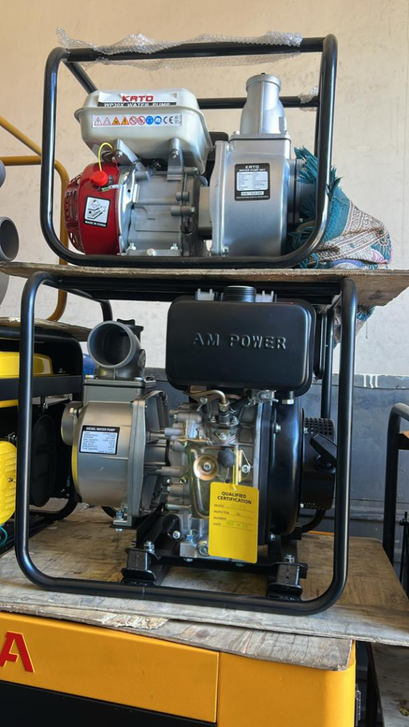 Two portable water pumps stacked on wooden pallets, top one KATO brand with red and silver engine, bottom one AM POWER diesel model